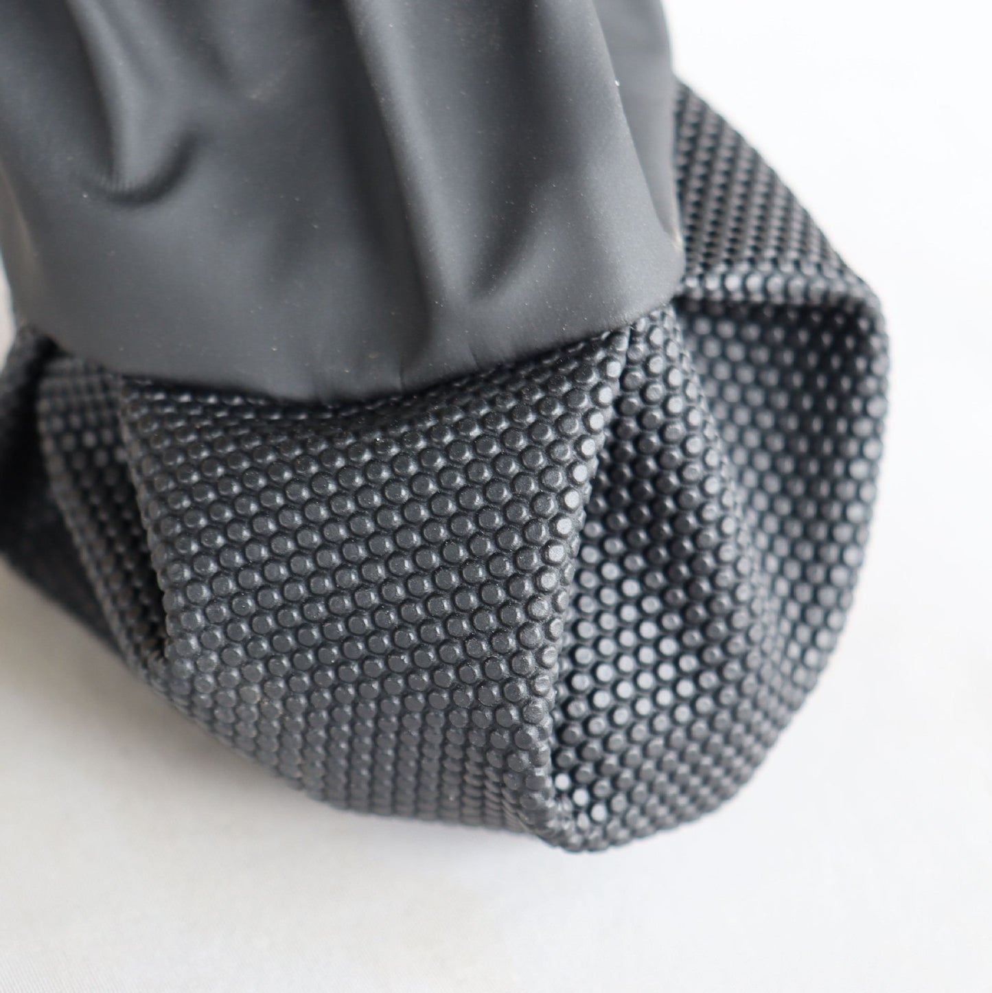 Close-up of a textured black sole of  suspender dog boots on a white background