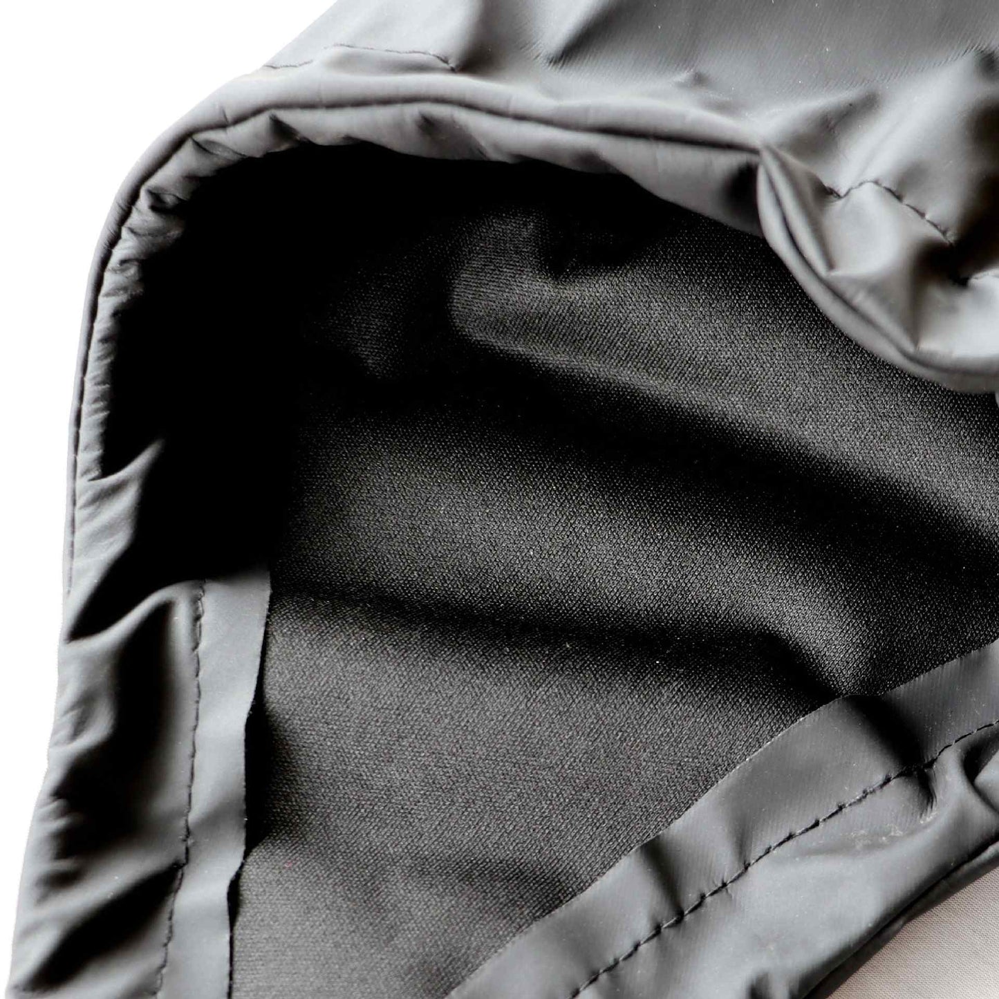 Close-up of gray fabric of suspender dog boots with a hood, showing texture and stitching details.