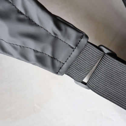 Close-up of a gray belt with a buckle of a  suspender dog boots on a neutral background