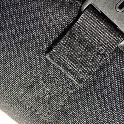 Close-up of a black strap with a textured surface and visible stitching on a gray background.